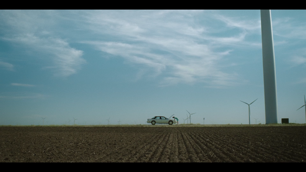 a woman checking her car in the windmill area