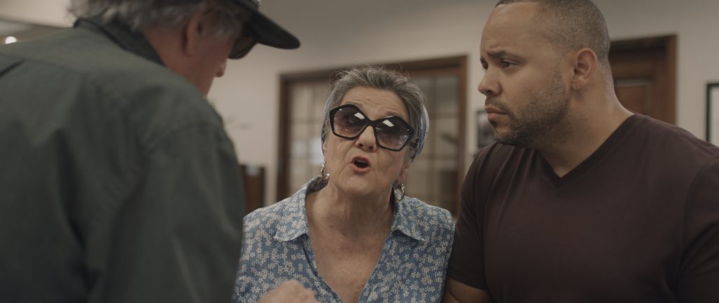 A woman wearing glasses talking to a man