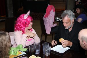 woman with a pink wig looking at a man