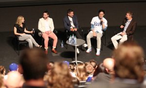 Five people sitting on a chair and having a discussion