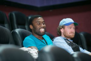 two men are sitting in a theater