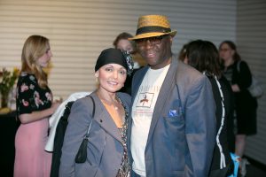 a man wearing a hat and a woman smiling