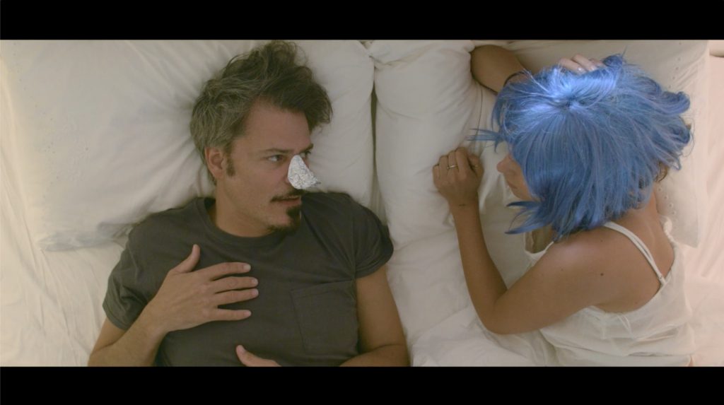 a man looking at a woman with blue hairs