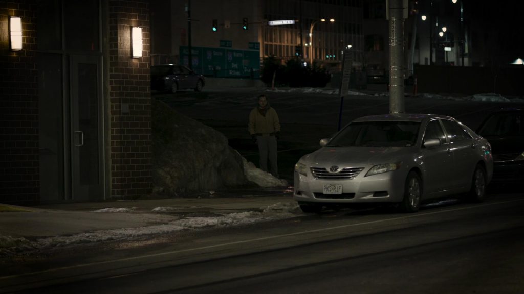 A Car and a man outside a house at night